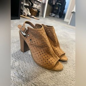 Tan heeled boots with open back.